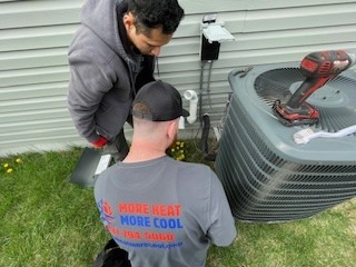 More Heat More Cool technicians servicing an HVAC unit