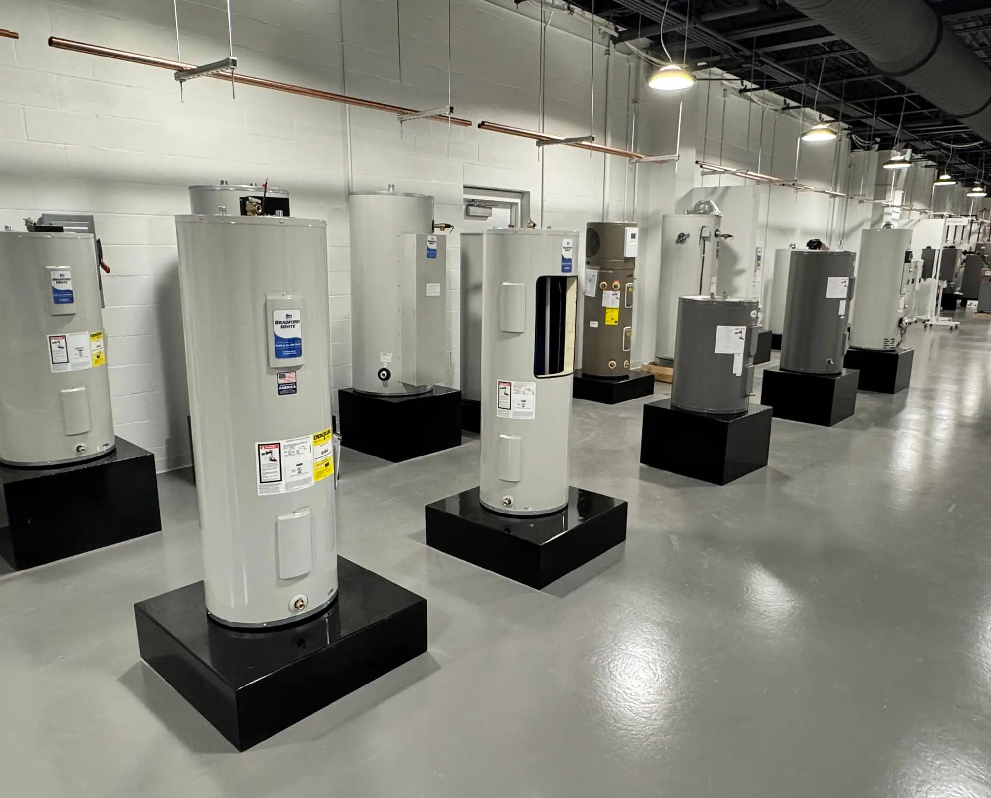 Water heater warehouse displaying a wide selection of tank water heaters available for installation