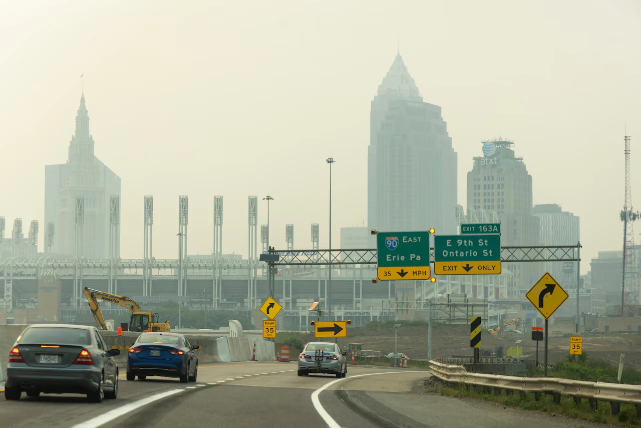 Wildfire smoke haze blanketing an Ohio city skyline and highway during a statewide air quality alert