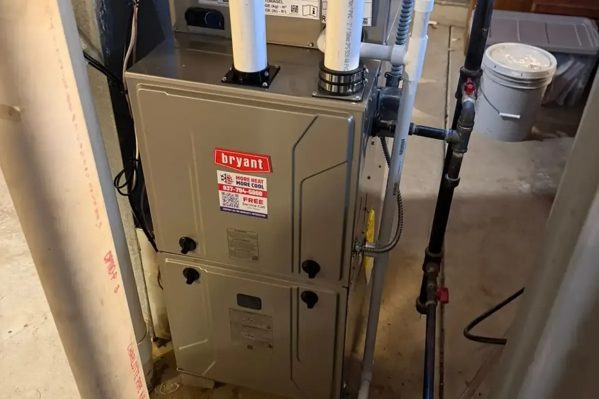 A newly installed high-efficiency gas furnace with white PVC vent pipes in a home basement