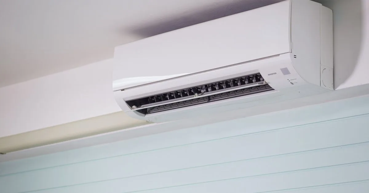 A white wall-mounted ductless mini-split indoor unit installed high on a living room wall